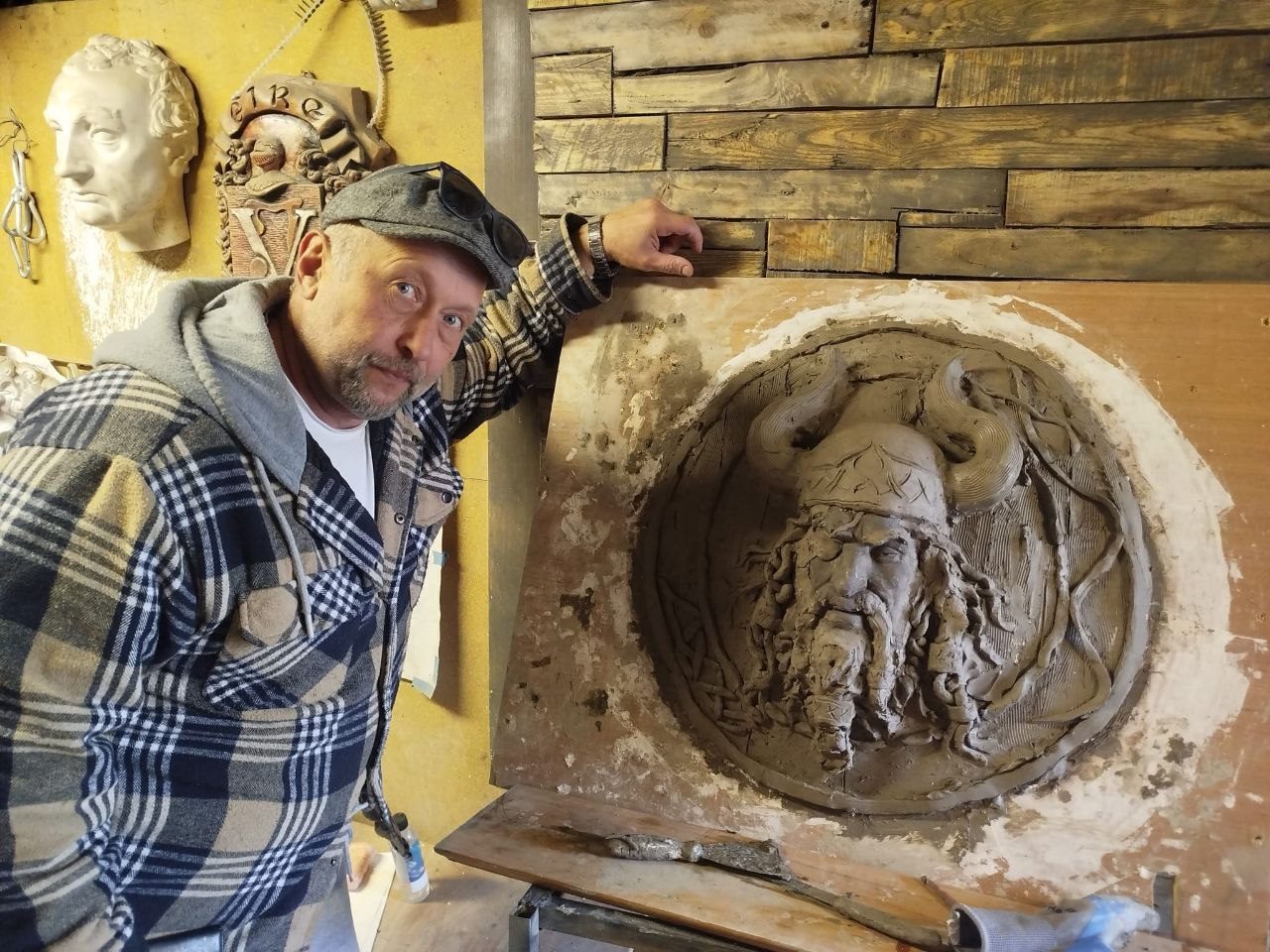 Sculptor modelling a Norse medallion in clay