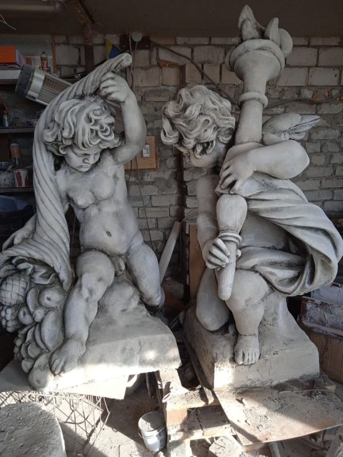 A pair of cast-stone putti sculptures